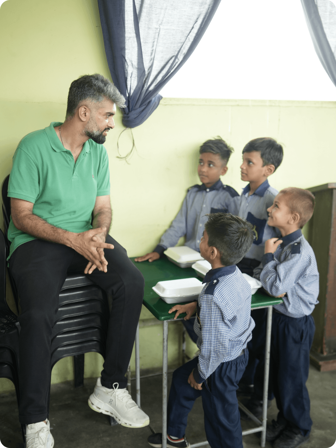 The founder sharing a meal with schoolchildren